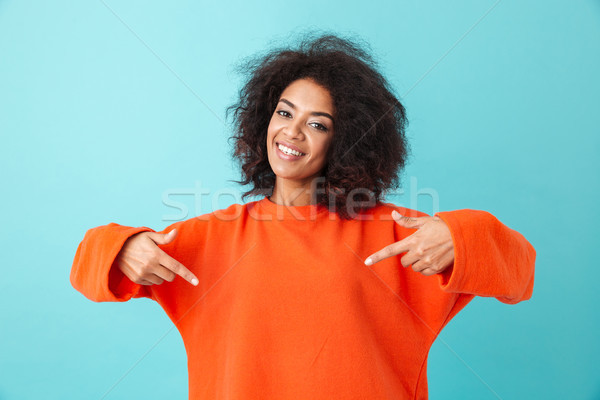 Photo of american woman in red shirt looking on camera and point Stock photo © deandrobot