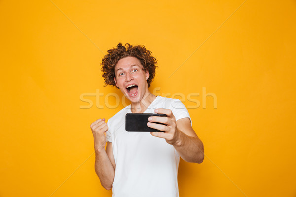 Attractive caucasian man with curly brown hair screaming and cle Stock photo © deandrobot