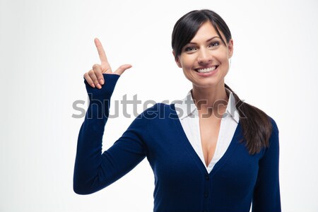 Smiling businesswoman pointing finger up  Stock photo © deandrobot