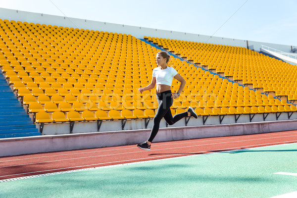 Woman running on stadium Stock photo © deandrobot