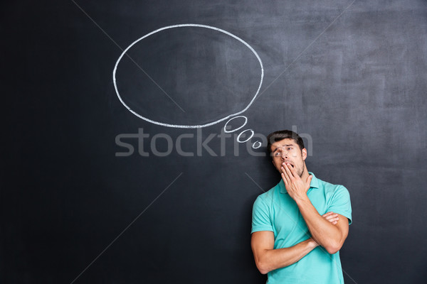 Bored tired young man standing and yawning Stock photo © deandrobot