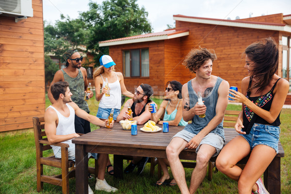 Happy young people drinking beer and having outdoor summer party Stock photo © deandrobot