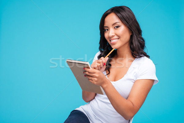 Asian woman thinking about something and holding notebook Stock photo © deandrobot