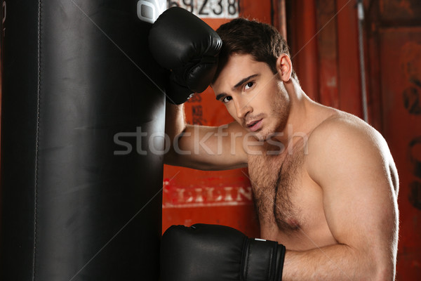 Tired boxer standing with punchbag Stock photo © deandrobot