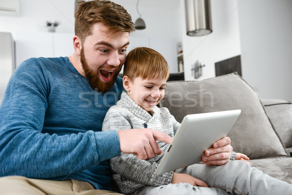 Emotional family using tablet computer indoors. Stock photo © deandrobot