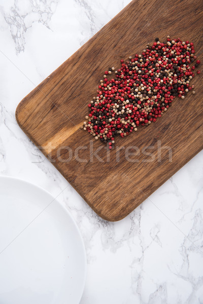 Spicy mixed peppercorns heap on a wooden cutting board Stock photo © deandrobot