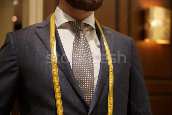 Cropped image of bearded man with measuring tape on neck Stock photo © deandrobot