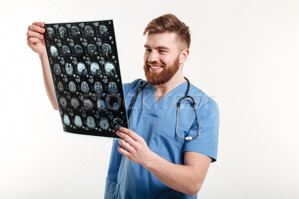 Portrait of a smiling medical doctor looking at CT scan Stock photo © deandrobot