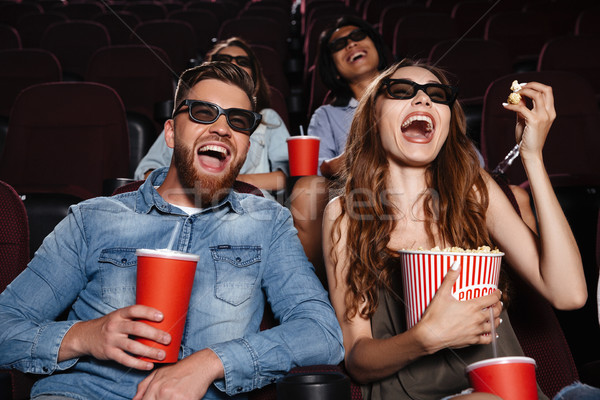 Laughing friends sitting in cinema watch film Stock photo © deandrobot