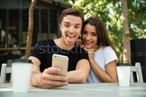 Portrait of a funny young couple taking selfie Stock photo © deandrobot