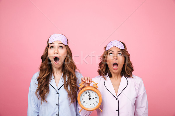 Megrémült barátok nők pizsama tart ébresztőóra Stock fotó © deandrobot