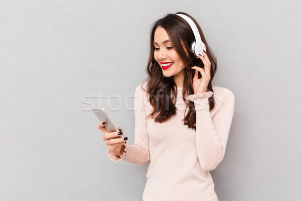 Half-turn photo of beautiful female with red lips smiling holdin Stock photo © deandrobot
