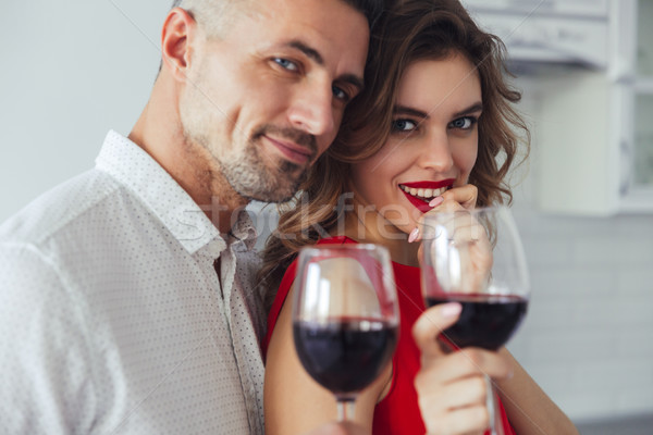 Portrait of lovers drinking wine and looking camera at home Stock photo © deandrobot