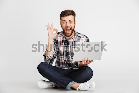 Portrait of a smiling young man in plaid shirt Stock photo © deandrobot