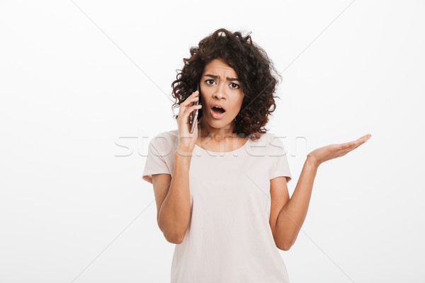 Portrait of serious puzzled woman with afro hairstyle wearing t- Stock photo © deandrobot