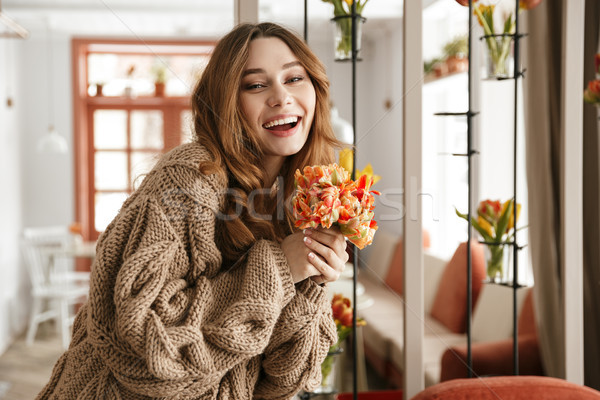 Photo of splendid woman 20s in knitted sweater, holding beautifu Stock photo © deandrobot