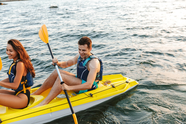 Loving couple kayaking on lake sea in boat Stock photo © deandrobot