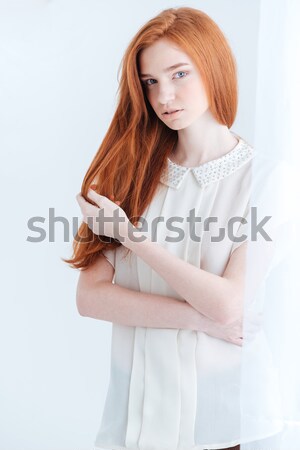 Attractive young woman holding her arms crossed on gray background Stock photo © deandrobot