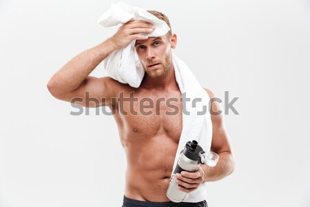Young man applying hair spray to his hair Stock photo © deandrobot