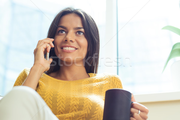 Businesswoman talking on the phone and looking up Stock photo © deandrobot