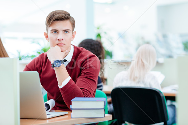 Thoughtful male student sitting with laptop computer Stock photo © deandrobot