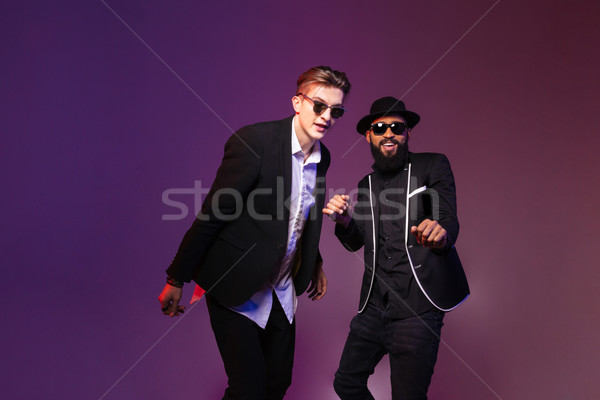 Two attractive cheerful young men in sunglasses dancing  Stock photo © deandrobot