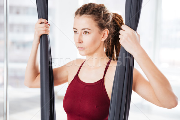 Concentrated woman using hammock in yoga studio Stock photo © deandrobot