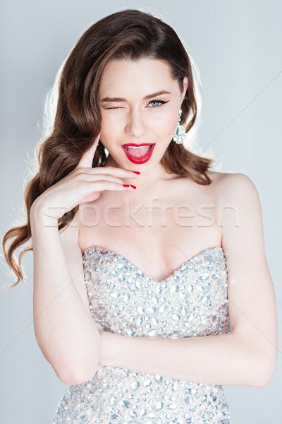 Cheerful woman in fashion dress winking  Stock photo © deandrobot