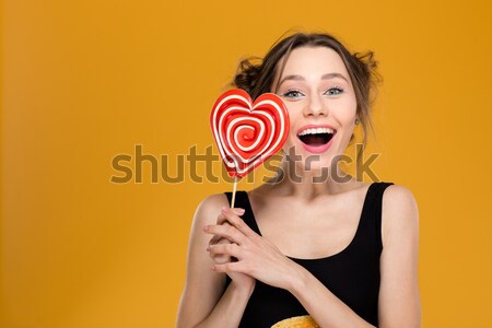 Közelkép gyönyörű mosolyog fiatal nő harap színes Stock fotó © deandrobot