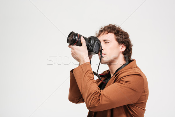 Young man photographing on professional camera Stock photo © deandrobot