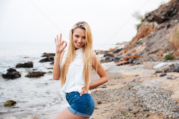 Stock photo: Beautiful woman showing ok sign on the beach