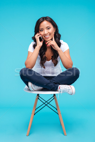 Happy young vietnamese woman talking on the phone Stock photo © deandrobot
