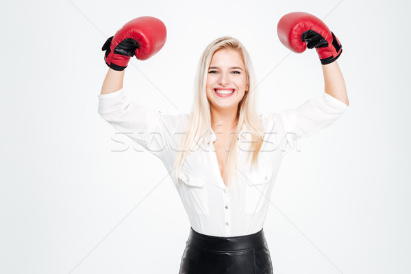 Cheerful young businesswoman in boxing gloves with raised hands Stock photo © deandrobot