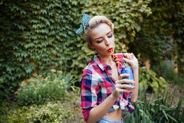 Beautiful pin up girl drinking soda in the park Stock photo © deandrobot