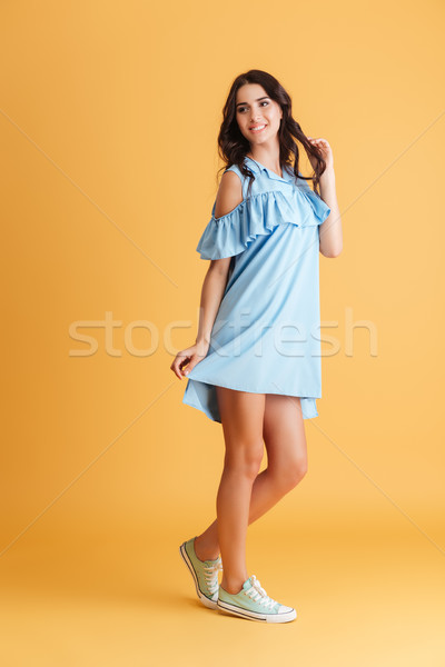 Full length portrait of a smiling cute woman posing Stock photo © deandrobot