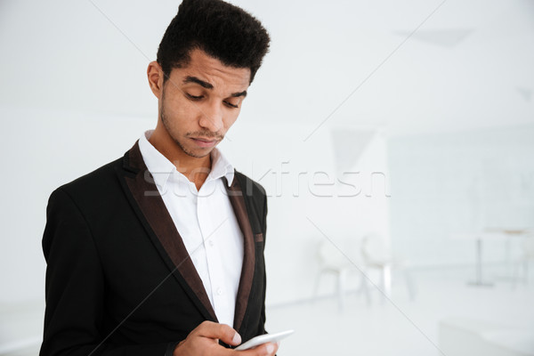 African business man writing message on phone Stock photo © deandrobot