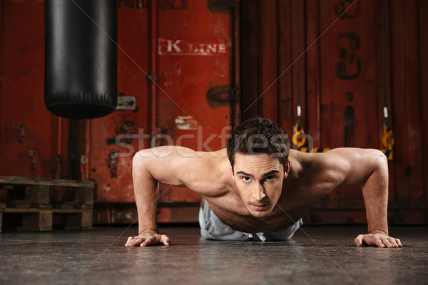 Stock photo: Photo of young strong man training in a gym.