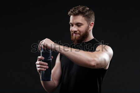 Jovem homem garrafa abrir isolado Foto stock © deandrobot