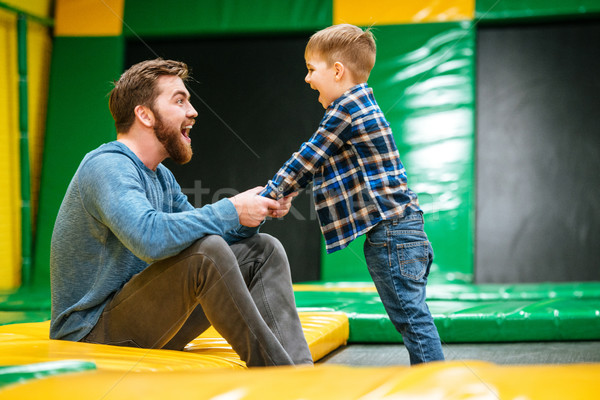 Cheerful dad and son having fun together at indoor playground Stock photo © deandrobot