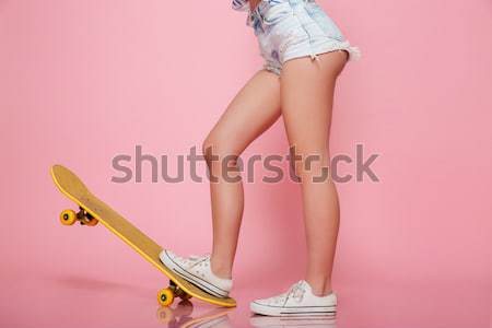 Foto stock: Feliz · mulher · jovem · óculos · de · sol · sessão · andar · de · skate · sorridente