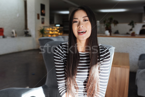 Asian woman with open mouth sitting in cafeteria Stock photo © deandrobot