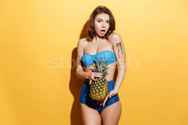 Elképesztő fiatal nő fürdőruha tart ananász kép Stock fotó © deandrobot