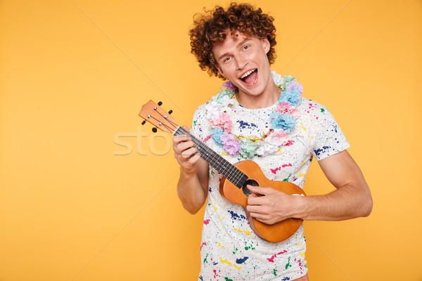 Attractive young man in summer clothes playing ukulele Stock photo © deandrobot