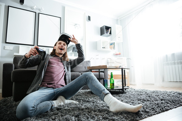 Happy man indoors play games with 3d virtual reality glasses Stock photo © deandrobot