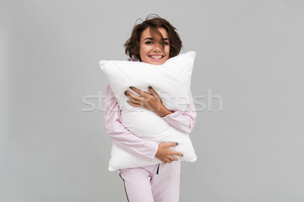 Portrait of a smiling girl in pajamas holding a pillow Stock photo © deandrobot
