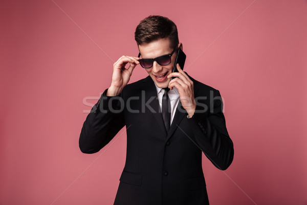Jovem despreocupado homem terno falante telefone Foto stock © deandrobot