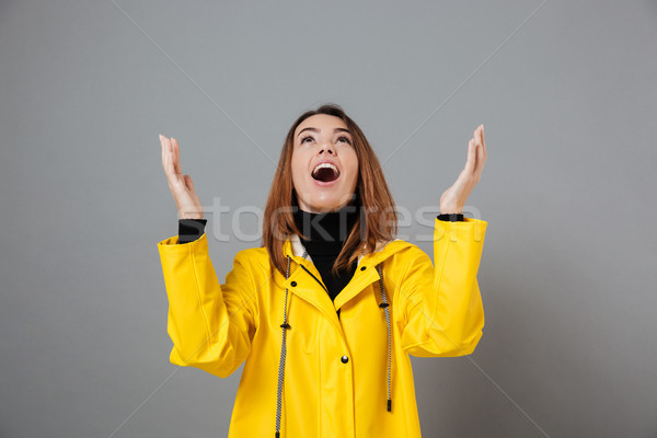 Portrait of a cheerful girl dressed in raincoat Stock photo © deandrobot