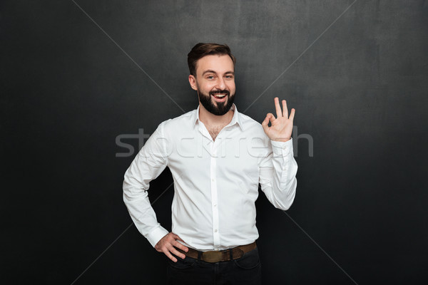 Adult guy in office posing on camera, smiling and gesturing with Stock photo © deandrobot