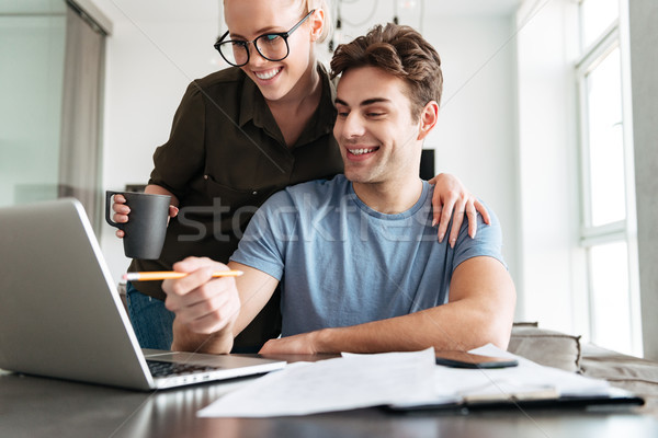улыбаясь пару используя ноутбук компьютер домой Lady Сток-фото © deandrobot