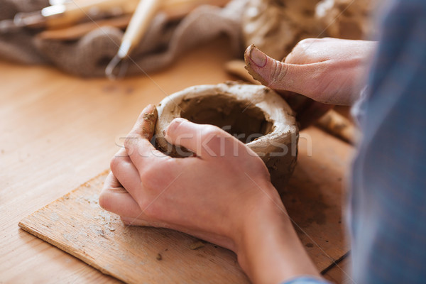Woman hands making pot using clay in pottery studio Stock photo © deandrobot